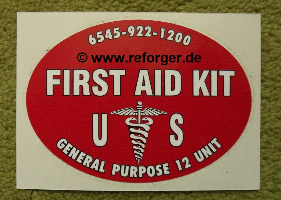 Ovaler Aufkleber mit der Aufschrift ‚FIRST AID KIT‘ und dem Esculabstab-Symbol sowie der Bezeichnung ‚U.S.‘ für US-Militärverbandskästen.