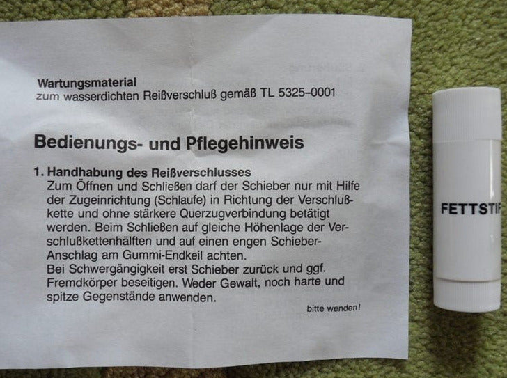 Packungsbeilage des Fettstifts für Reißverschlüsse mit detaillierten Bedienungs- und Pflegehinweisen zur richtigen Anwendung und Wartung von Reißverschlüssen