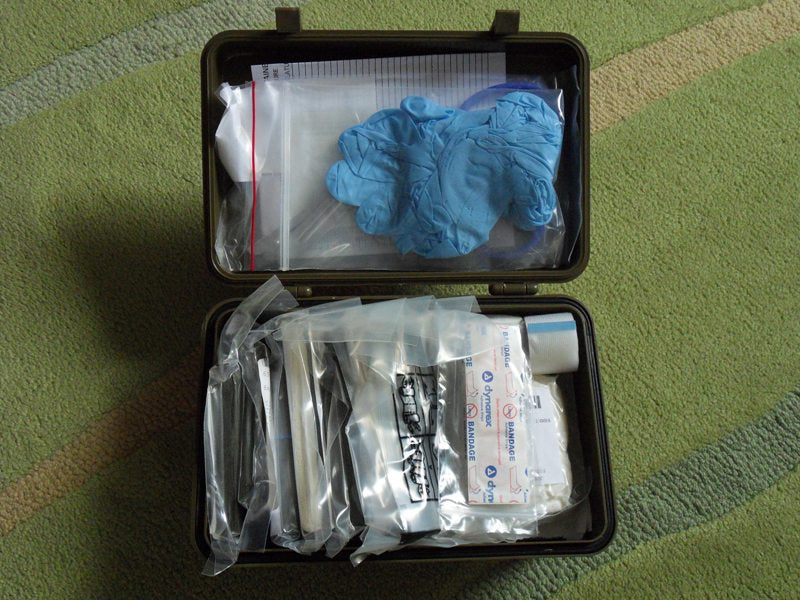 Geöffneter US Army First Aid Kit – General Purpose, olivgrüne Kunststoffbox mit vollständigem Inhalt für Erste Hilfe